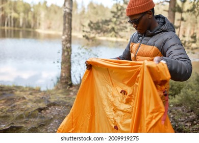 Guy Try To Understand How To Set Tent For Sleepover. Beautiful Nature Landscape On Background. Lake And Silent Forest. Best Time For Camping. Travelling And Exploring Life Concept