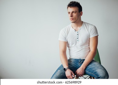 The guy in the t-shirt and spend hours sitting on a chair in front of a white wall, men's looks - Powered by Shutterstock