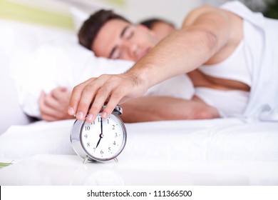guy turning off alarm clock