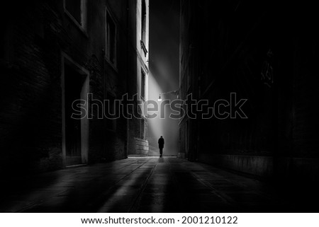 guy is walking along through dark city