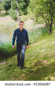 Guy, walking in park throw trees.