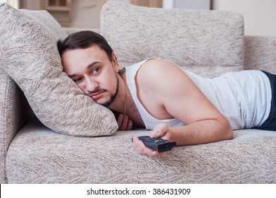 guy is watching an interesting movie on the couch