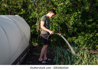 Guy Watering A Hose In The Garden