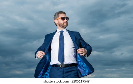 Guy Wearing Open Suit Jacket Fluttering In Wind Sky Background