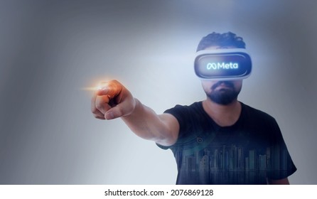 Guy Wearing Virtual Reality Goggles Inside A Metaverse Touching Screen Logo - Meta Written On The Googles