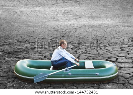 Guy will rows home for shore in paddle powered row boat businessman in boat rocks looks bright future symbol crisis stagnation losses braking difficulties environmental disaster water scarcity drought
