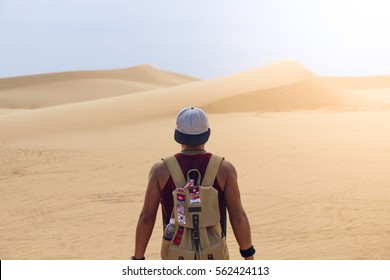 Guy Young Man Alone With A Travel Backpack In A Desert Background.