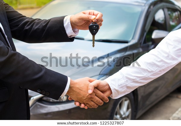 Guys give\
the car keys to customers and shake\
hands.
