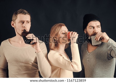 Guys hold cup, flask with alcohol, drink. Company of calm friends spend leisure with drinks. Alcohol, friendship, fun. Men, woman on pensive faces, dark background. Drink alcohol concept.
