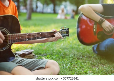 Guys Play Guitars In City Park Outdoor