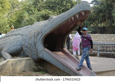 Gwalior, Madhya Pradesh / India - November 26,2012: Beautiful child playing with crocodile shape (idol) of in Zoo of Gwalior