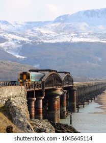 Gwynedd, North Wales / UK - 02/28/2018: Cambrian Line British Rail Class 158 Diesel Multiple Unit (DMU) On Barmouth Viaduct. 