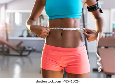 Gym afro woman loosing weight and taking measurements