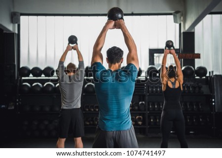 Gym class doing exercise with kettle bells