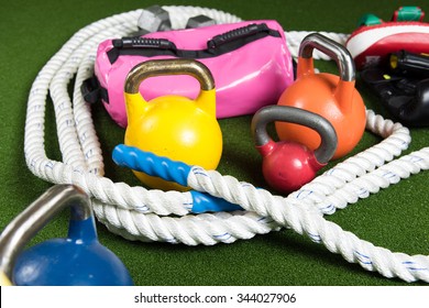 Gym Equipment For Bootcamp Type Classes.  Kettle Bells, Rope, Dumbbells On Green Turf
