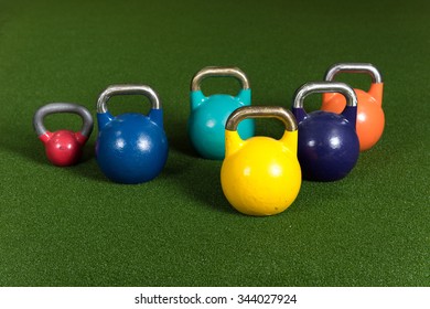 Gym Equipment For Bootcamp Type Classes.  Variable Weight Kettle Bells On Green Turf