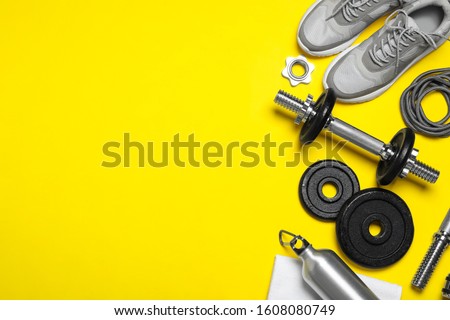 Gym equipment on yellow background, flat lay. Space for text