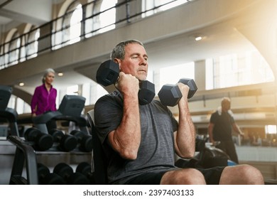 Gym, fitness and senior man with dumbbells for weightlifting, challenge or cardio workout, training or bodybuilding. Biceps, arms and elderly person with hand weight for strength, mindset or exercise - Powered by Shutterstock