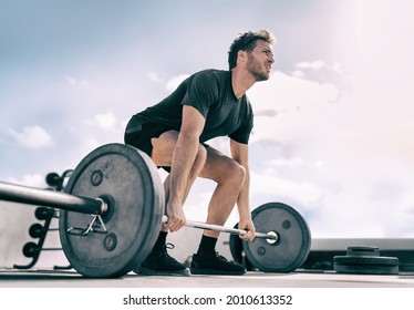Gym fitness weightlifting deadlift man bodybuilding powerlifting at outdoor summer health club. Bodybuilder doing barbell weight lifting training workout with heavy bar.