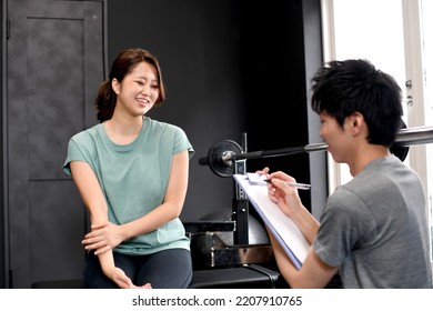 Gym instructor (trainer) man and member woman having a conversation - Powered by Shutterstock