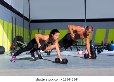 Gym Man And Woman Push-up Strength Pushup With Dumbbell In A Fitness Workout