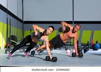 Gym Man And Woman Push-up Strength Pushup With Dumbbell In A Fitness Workout