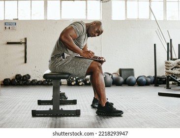 Gym membership, personal trainer and black man writing on clipboard for exercise, training or workout schedule and program. Male sports coach working on health, wellness and fitness plan or goals - Powered by Shutterstock