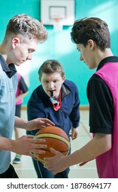 Gym Teacher Initiating A Basketball Tip-off For High School Students.