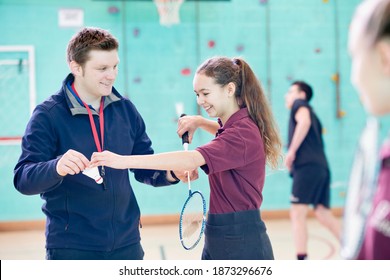 Gym Teacher Teaching A High School Student Badminton At The Gymnasium.