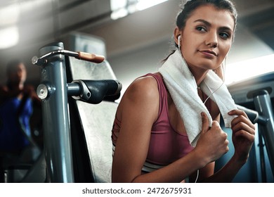 Gym, towel and woman with health break, prepare and warm up for intense weight performance. Sport, earphones and female athlete thinking for fitness, training and chest press exercise for strength - Powered by Shutterstock