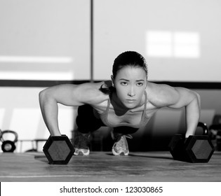 Gym woman push-up strength pushup exercise with dumbbell in a fitness workout - Powered by Shutterstock