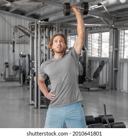 Gym Workout Fitness Man Training With Dumbbells Lifting Overhead Raise Shoulders Exercise Shoulder Press Indoors At Health Club. Square Crop.