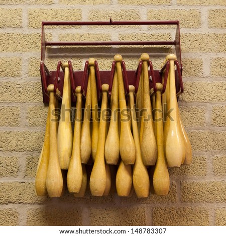 Gymnastic wooden clubs in a rack on the wall