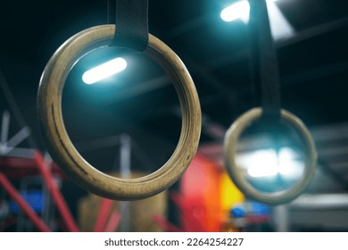 Gymnastics ring, training and equipment in an empty gym for olympics preparation closeup from below. Exercise, health and interior with sports rings in a fitness center for an olympic workout - Powered by Shutterstock