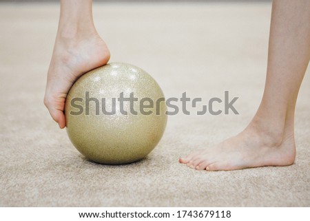 gymnast's legs with ball close up. ballet stand on the toes. sports exercises and stretching: athletics