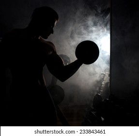 In The Gym.Silhouette Of Bodybuilder With Dumbell