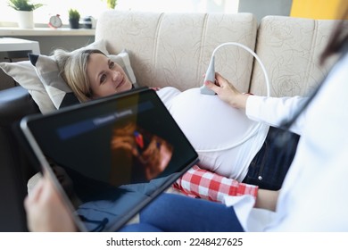 Gynecologist conducts ultrasound of pregnant woman at home - Powered by Shutterstock