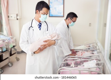 Gynecologist Doctor Holding A Newborn Baby