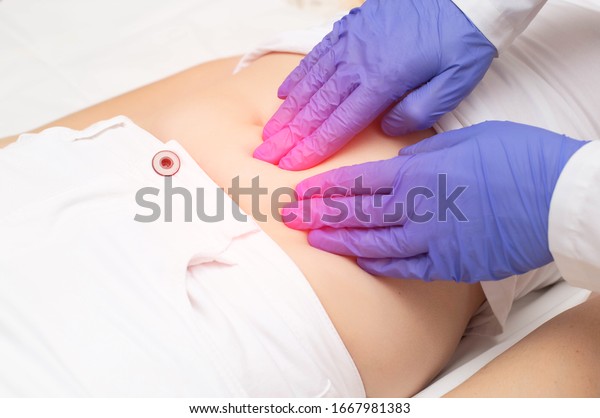 A gynecologist doctor\
probes the lower abdomen of a girl who has pain and inflammation of\
the reproductive system. Ovarian cyst, endometriosis, pregnancy\
pathology