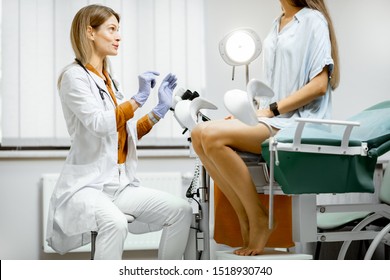 Gynecologist preparing for an examination procedure for a pregnant woman sitting on a gynecological chair in the office - Shutterstock ID 1518930740