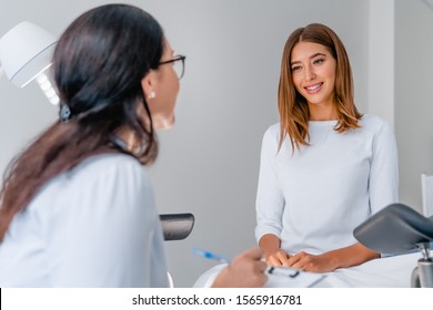Gynecologist Talking With Young Female Patient During Medical Consultation In Modern Clinic