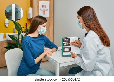 Gynecology, consultation of gynecologist, women's health. Gynecologist showing to woman ultrasound of her ovaries during female patient visit to gynecology