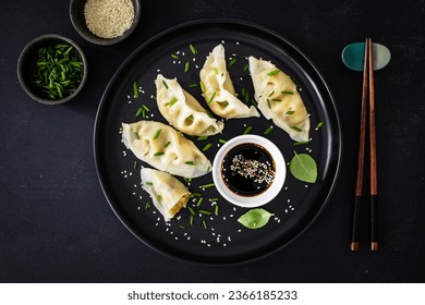 Gyoza - traditional japanese delicious dumplings filled with vegetables wrapped into thin dough served with soy sauce on wooden table 