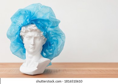 Gypsum Copy Of David's Head In Surgical Cap. Michelangelo's David Plaster Bust, Ancient Sculpture, Statue On Wooden Table. Medicine Concept, Operation, Plastic Surgery And Beauty Theme. Copyspace