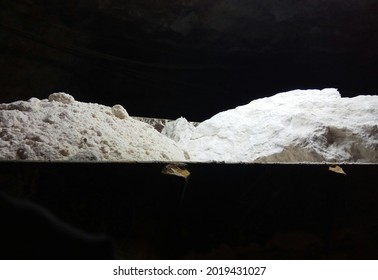 Gypsum Mining. Pile Of Plaster. Trolley With White Plaster On A Black Background