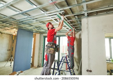 Gypsum Plasterboard Work. Drywall Construction At Home. Contractor Worker Installing Metal Frame On Ceiling