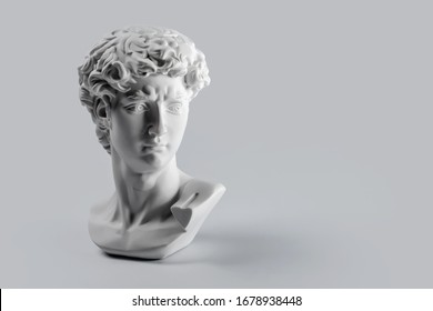 Gypsum statue of David's head. Michelangelo's David statue plaster copy on grey background with copyspace for text. Ancient greek sculpture, statue of hero - Shutterstock ID 1678938448