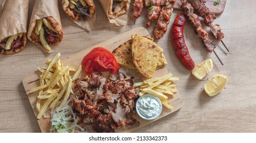 Gyro Greek sliced meat traditional street food. Ethnic dish, pita bread, tzatziki yogurt potato and onion on wooden table, top view