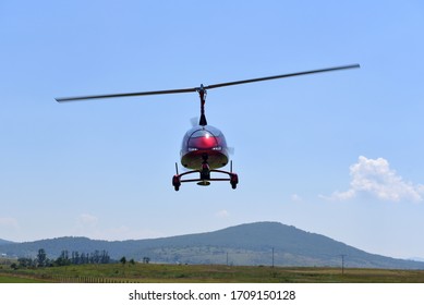 Gyrocopter flying with background of blue sky