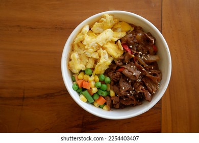 Gyudon, Japanese traditional dish made from flavored thinly sliced beef, soy sauce and onion served over a bowl of steaming rice, combined with scrambled eggs - Shutterstock ID 2254403407